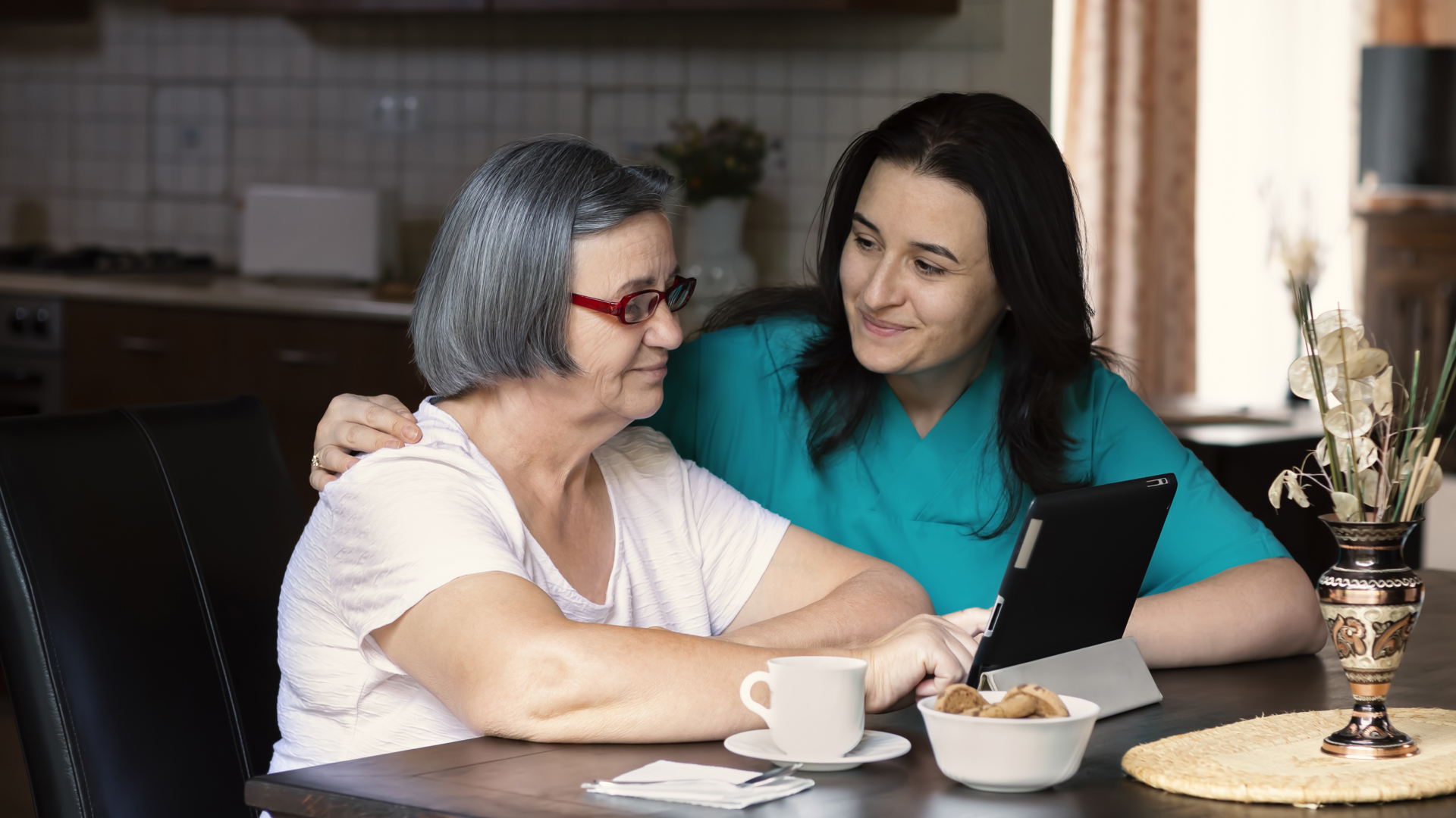 Mp38119532 Caring Nurse Showing A Digital Tablet To An Elderly Woman Mindre