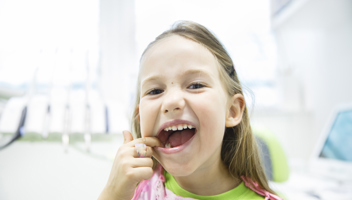 12859387 Girl Showing Her Healthy Milk Teeth At Dental Office