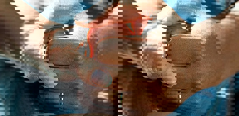 Två händer som håller hand inom vården